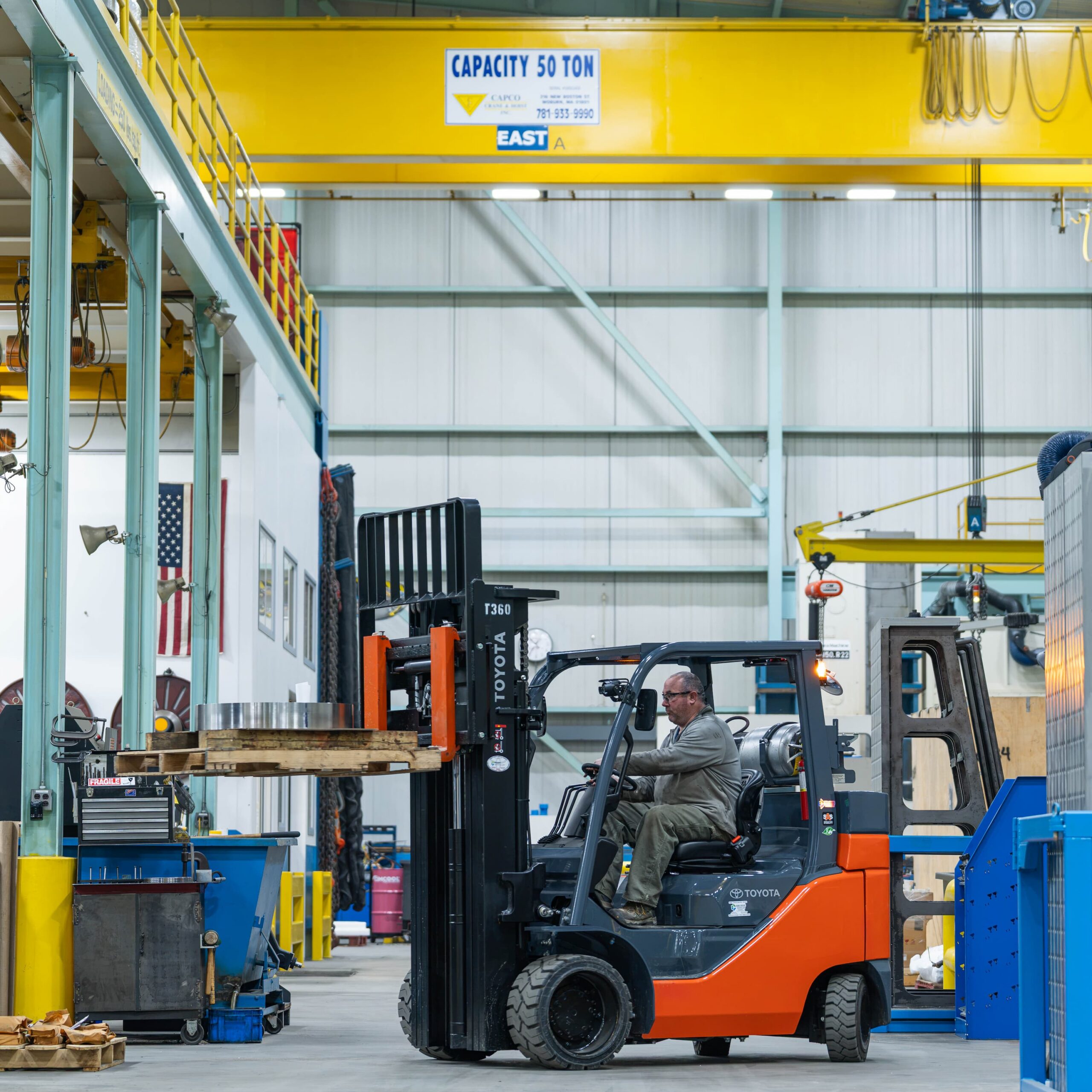 A forklift operates in a warehouse, lifting pallets for efficient storage and organization of goods.