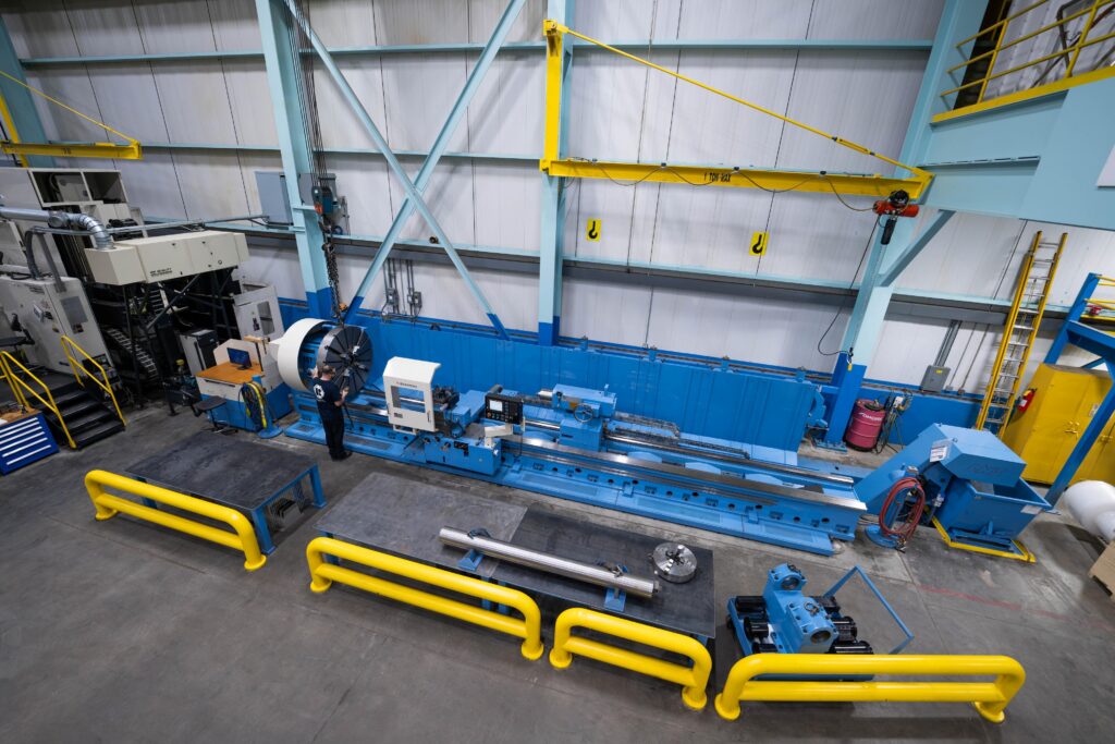 A spacious machine shop featuring blue and yellow equipment, showcasing various tools and machinery for manufacturing.