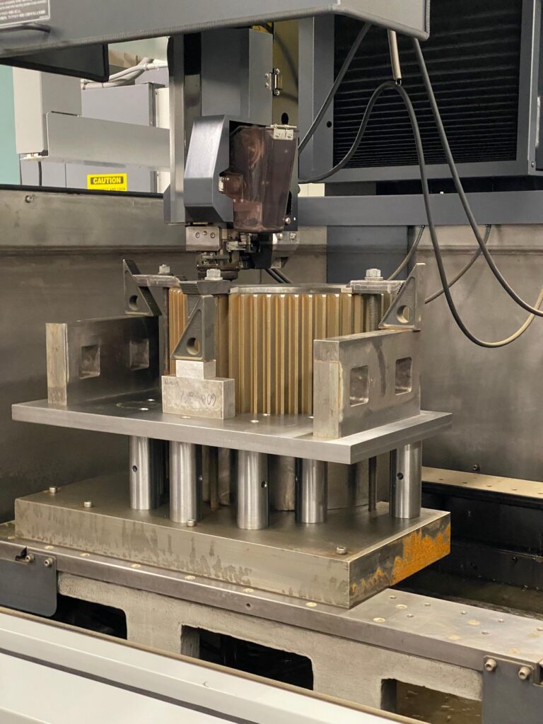 A metal cutting machine in a factory, with sparks flying as it processes a steel sheet.